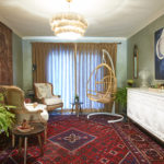 wide shot of dining toom makeover into library sitting room with burlap drapes, rosewood and marble table, vintage rugs, chandelier, affordable art, new paint finish e
