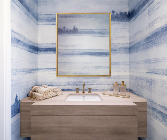 A powder room with ombre blue wallpaper mural