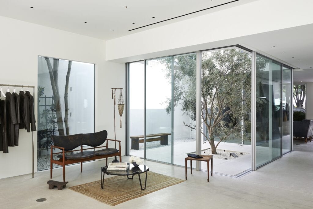 A minimalist Californian interior with an attached courtyard with a single tree in a biophilic home