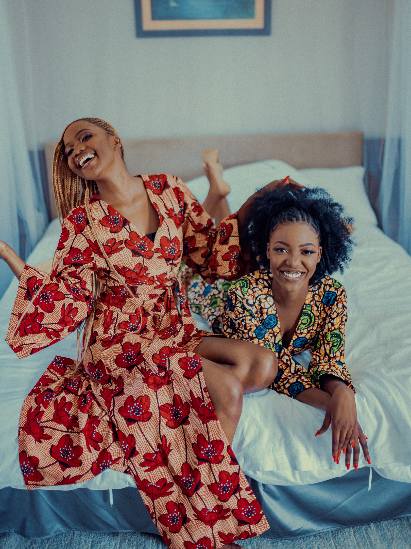 Two young women practicing self care in brightly patterned loungewear made and designed in Africa